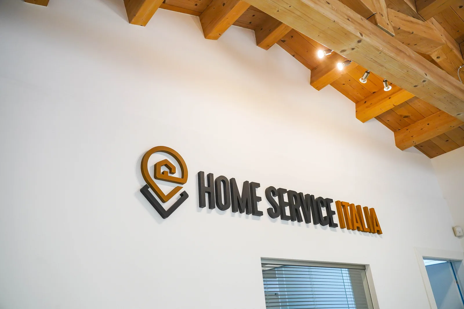 Il marchio restaurato in lettere a rilievo sulla parete dell'ufficio di Home Service Italia