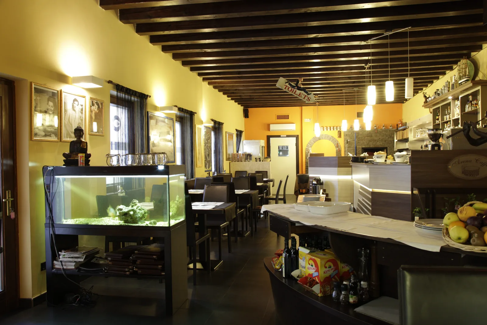 La sala del ristorante Il Calice, con il bancone e il forno sullo sfondo