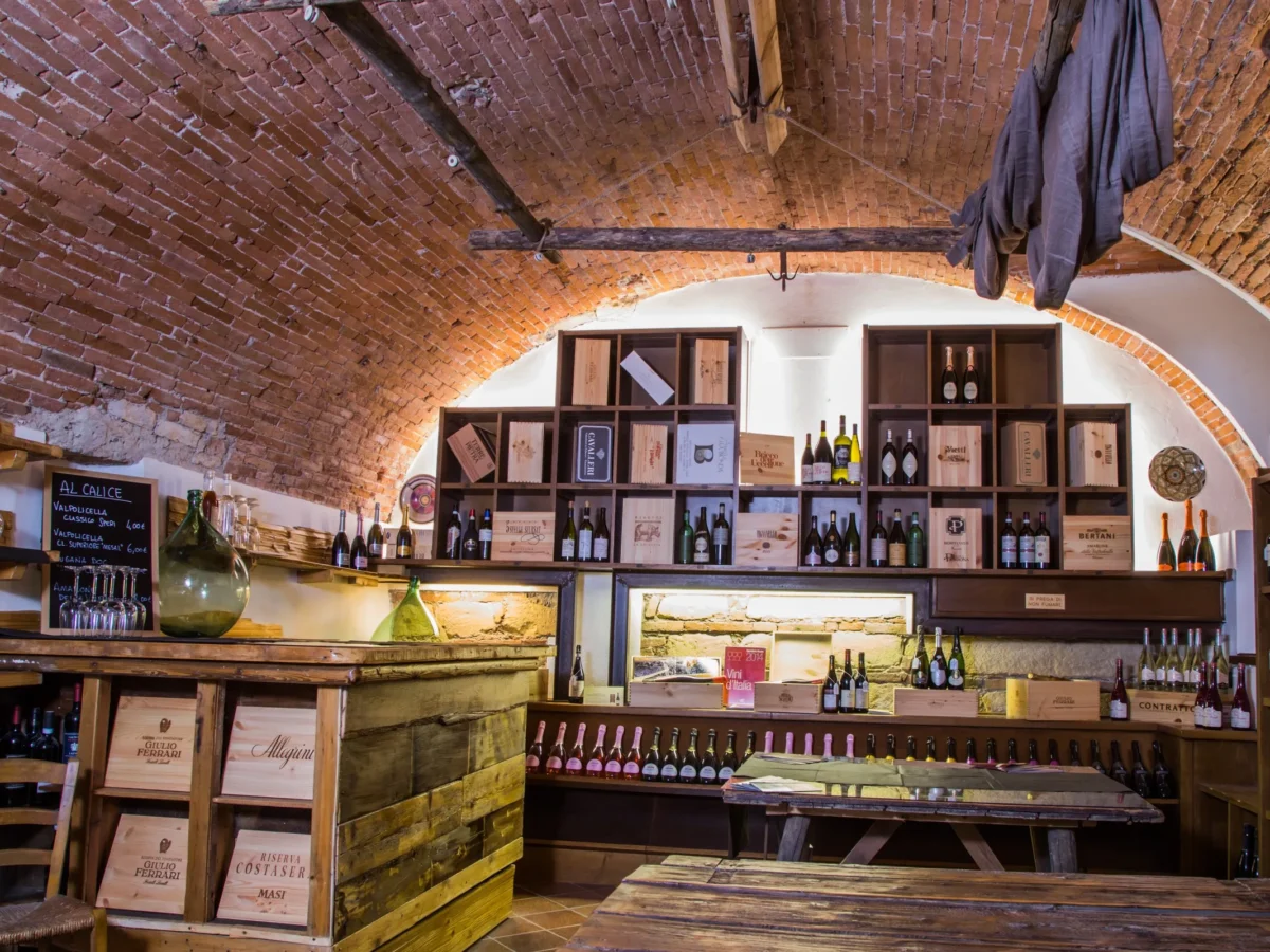 La cantina a volta del Calice, con le cassette di vino e il tavolo da degustazione