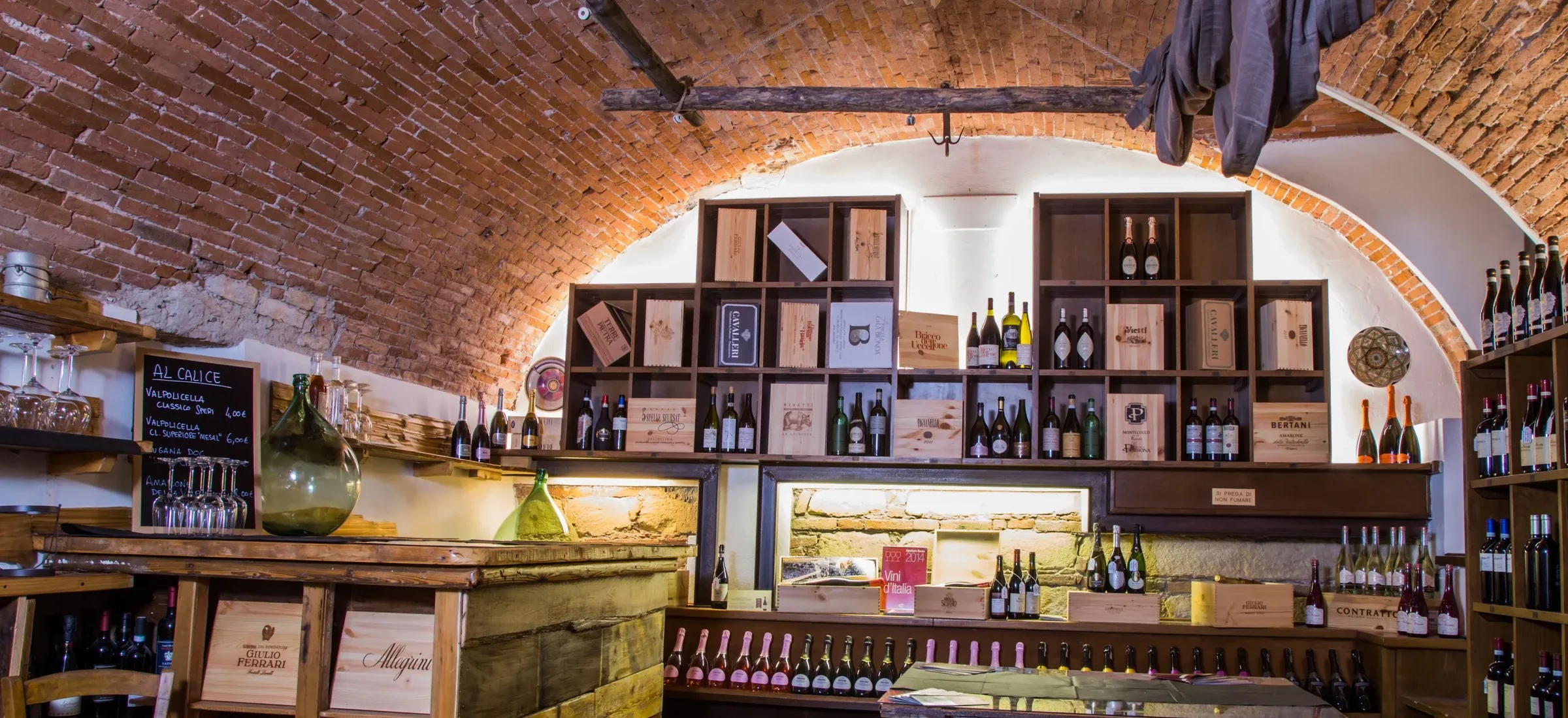 La cantina a volta del Calice, con le cassette di vino e il tavolo da degustazione